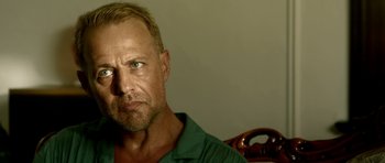 Movie still from “The Debt Collector” (2018), directed by Jesse V. Johnson – A person wearing a green shirt; Close Up shot, Low angle