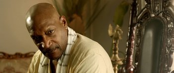 Movie still from “The Debt Collector” (2018), directed by Jesse V. Johnson – A bald man with a white shirt and a white jacket; Close Up shot, Over the shoulder angle