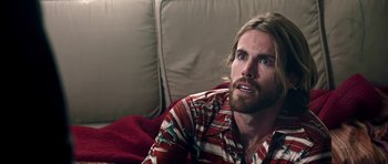 Movie still from “The Debt Collector” (2018), directed by Jesse V. Johnson – A person sitting on a couch; Close Up shot, Over the shoulder angle