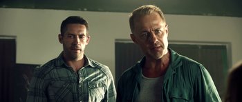 Movie still from “The Debt Collector” (2018), directed by Jesse V. Johnson – Two men standing next to each other in front of a mirror; Close Up shot, Over the shoulder angle