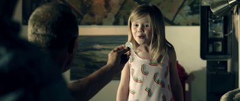 Movie still from “The Debt Collector” (2018), directed by Jesse V. Johnson – A man putting a coin in a girl's mouth; Close Up shot, Over the shoulder angle