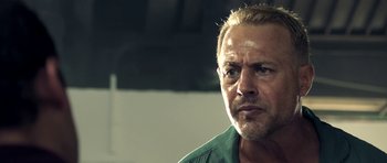 Movie still from “The Debt Collector” (2018), directed by Jesse V. Johnson – A person wearing a green shirt; Close Up shot, Low angle