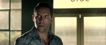 Movie still from “The Debt Collector” (2018), directed by Jesse V. Johnson – A person wearing a plaid shirt; Close Up shot, Over the shoulder angle