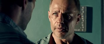 Movie still from “The Debt Collector” (2018), directed by Jesse V. Johnson – A person with a green shirt; Close Up shot, Over the shoulder angle