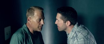 Movie still from “The Debt Collector” (2018), directed by Jesse V. Johnson – Two men face each other in a room; Close Up shot, Over the shoulder angle