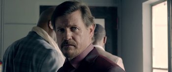 Movie still from “The Debt Collector” (2018), directed by Jesse V. Johnson – A person wearing a suit and tie; Close Up shot, Over the shoulder angle