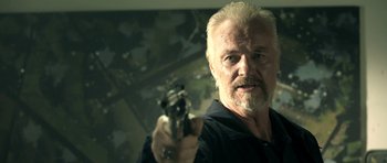 Movie still from “The Debt Collector” (2018), directed by Jesse V. Johnson – An older man holding a gun in his hand; Close Up shot, Low angle