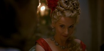 Movie still from “Bridgerton” (2020), created by Chris Van Dusen – A woman in a red dress with a red flower in her hair; Close Up shot, Over the shoulder angle