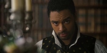 Movie still from “Bridgerton” (2020), created by Chris Van Dusen – A person wearing a vest looking at the camera; Close Up shot, Over the shoulder angle