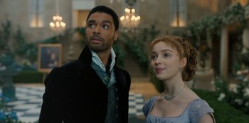 Movie still from “Bridgerton” (2020), created by Chris Van Dusen – A man and a woman standing next to each other; Medium shot, Over the shoulder angle