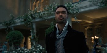 Movie still from “Bridgerton” (2020), created by Chris Van Dusen – A man wearing a black jacket and a paisley tie; Close Up shot, Over the shoulder angle