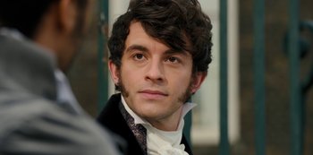 Movie still from “Bridgerton” (2020), created by Chris Van Dusen – A person wearing a suit and tie; Close Up shot, Over the shoulder angle