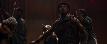 Movie still from “The Expendables” (2010), directed by Sylvester Stallone – A man in a red hat holding a gun; Close Up shot, Low angle