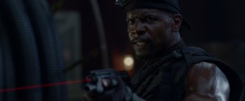 Movie still from “The Expendables” (2010), directed by Sylvester Stallone – A person holding a gun in a dark place; Close Up shot, Over the shoulder angle