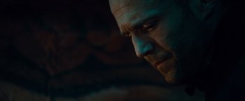 Movie still from “The Expendables” (2010), directed by Sylvester Stallone – A man's face in the dark; Close Up shot, Low angle