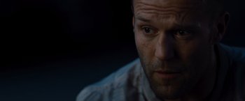 Movie still from “The Expendables” (2010), directed by Sylvester Stallone – A man's face in the dark; Close Up shot, Low angle