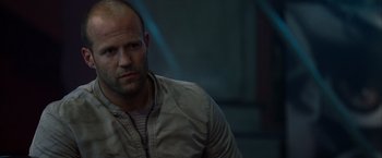 Movie still from “The Expendables” (2010), directed by Sylvester Stallone – A man with a bald head is looking at the camera; Close Up shot, Low angle