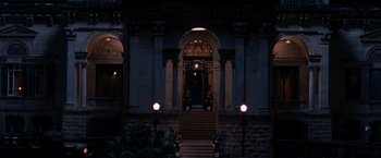 Movie still from “The Expendables” (2010), directed by Sylvester Stallone – The entrance to a building lit up at night; Extreme Wide shot, Low angle