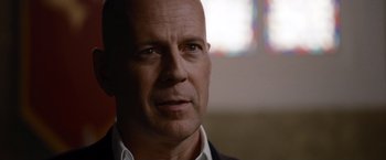 Movie still from “The Expendables” (2010), directed by Sylvester Stallone – A man with a bald head is looking at the camera; Close Up shot, Low angle