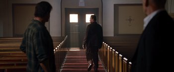 Movie still from “The Expendables” (2010), directed by Sylvester Stallone – A man walking down the stairs of a church; Wide shot, Low angle