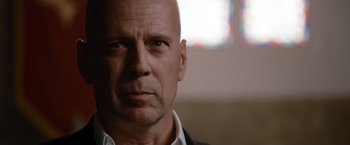 Movie still from “The Expendables” (2010), directed by Sylvester Stallone – A man with a bald head looking into the camera; Close Up shot, Low angle