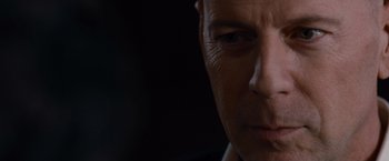 Movie still from “The Expendables” (2010), directed by Sylvester Stallone – A man's face in front of a black background; Extreme Close Up shot, Over the shoulder angle
