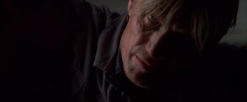 Movie still from “The Expendables” (2010), directed by Sylvester Stallone – A man's face in the dark; Close Up shot, Low angle