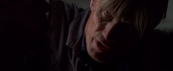 Movie still from “The Expendables” (2010), directed by Sylvester Stallone – A man's face in the dark; Close Up shot, Low angle