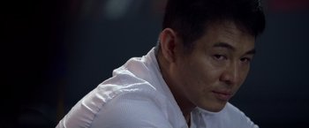 Movie still from “The Expendables” (2010), directed by Sylvester Stallone – A person wearing a white shirt; Close Up shot, Over the shoulder angle