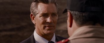 Movie still from “The Expendables” (2010), directed by Sylvester Stallone – A man in a suit talking to another man; Close Up shot, Over the shoulder angle