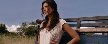 Movie still from “The Expendables” (2010), directed by Sylvester Stallone – A beautiful young woman standing on top of a bench; Close Up shot, Low angle
