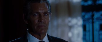 Movie still from “The Expendables” (2010), directed by Sylvester Stallone – A man in a suit and tie; Close Up shot, Over the shoulder angle