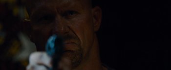 Movie still from “The Expendables” (2010), directed by Sylvester Stallone – A person holding a gun in his hand; Close Up shot, Low angle