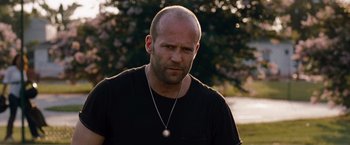 Movie still from “The Expendables” (2010), directed by Sylvester Stallone – A bald man with a beard and a necklace; Close Up shot, Over the shoulder angle