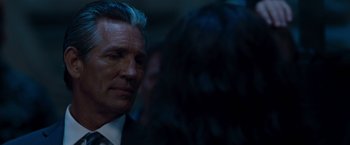 Movie still from “The Expendables” (2010), directed by Sylvester Stallone – A man in a suit and tie; Close Up shot, Over the shoulder angle