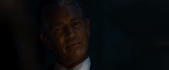 Movie still from “The Expendables” (2010), directed by Sylvester Stallone – A person wearing a suit and tie; Close Up shot, Over the shoulder angle