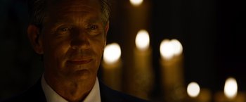 Movie still from “The Expendables” (2010), directed by Sylvester Stallone – A person wearing a suit and tie; Close Up shot, Over the shoulder angle