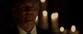 Movie still from “The Expendables” (2010), directed by Sylvester Stallone – A person wearing a suit and tie; Close Up shot, Over the shoulder angle