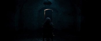 Movie still from “The Expendables” (2010), directed by Sylvester Stallone – A person sitting in front of a mirror in a dark room; Wide shot, High angle