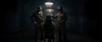 Movie still from “The Expendables” (2010), directed by Sylvester Stallone – A group of men standing next to each other in a dark room; Wide shot, Low angle