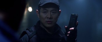 Movie still from “The Expendables” (2010), directed by Sylvester Stallone – A man holding a gun while wearing a hat; Close Up shot, Low angle