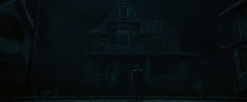 Movie still from “The Fall of the House of Usher” (2023), directed by Mike Flanagan – A man standing in front of a house at night; Wide shot, Low angle
