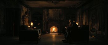 Movie still from “The Fall of the House of Usher” (2023), directed by Mike Flanagan – Two people sitting in front of a fire in a living room; Wide shot, Low angle