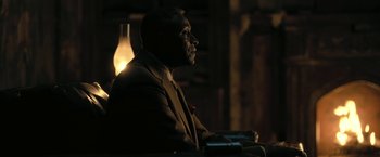 Movie still from “The Fall of the House of Usher” (2023), directed by Mike Flanagan – A man sitting in a chair in a dark room; Close Up shot, Low angle