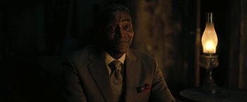Movie still from “The Fall of the House of Usher” (2023), directed by Mike Flanagan – A man wearing a suit and tie in the dark; Close Up shot, Over the shoulder angle