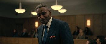 Movie still from “The Fall of the House of Usher” (2023), directed by Mike Flanagan – A man wearing a suit and tie in a courtroom; Close Up shot, Over the shoulder angle