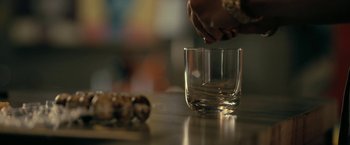 A person is putting something in a glass