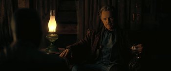 Movie still from “The Fall of the House of Usher” (2023), directed by Mike Flanagan – An older man sitting in a chair next to a lamp; Medium shot, Low angle