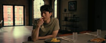 Movie still from “The Fall of the House of Usher” (2023), directed by Mike Flanagan – A man sitting at a table with a plate of food; Medium shot, Over the shoulder angle