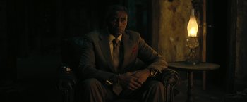 Movie still from “The Fall of the House of Usher” (2023), directed by Mike Flanagan – A man in a suit and tie sitting in a chair; Close Up shot, Low angle